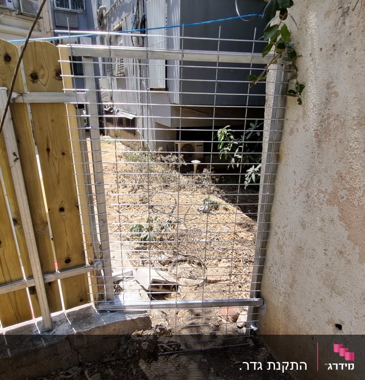 שער מתכת עם מסגרת עץ ליד קיר בטון